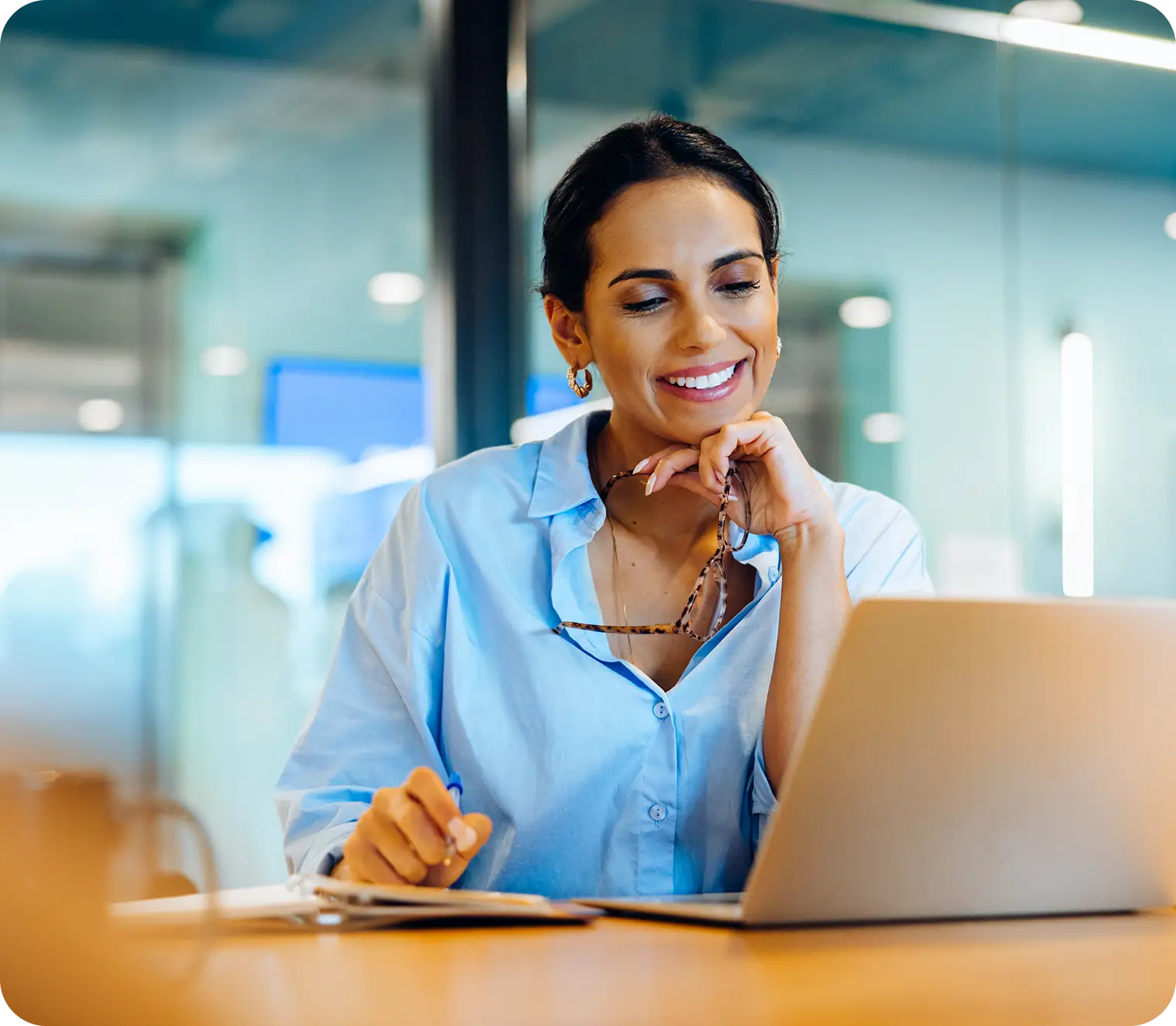 A lady smiling at the laptop